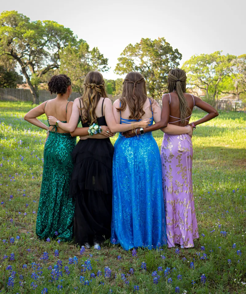 Friends in formal dresses, arms around each other